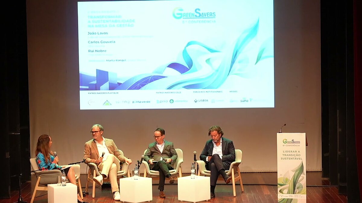 Palco da 8.ª Conferência Green Savers com a mesa-debate Transformar e o ecrã com os nomes dos oradores